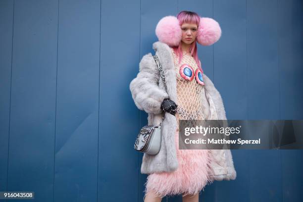 Liz Harlan is seen on the street attending Laurence & Chico during New York Fashion Week wearing oversized pink earmuffs, a grey fur coat, red/blue...