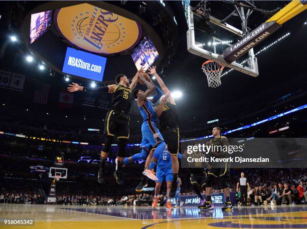 Paul George of the Oklahoma City Thunder drives to the basket against Josh Hart and Brook Lopez of the Los Angeles Lakers during the first half of a...