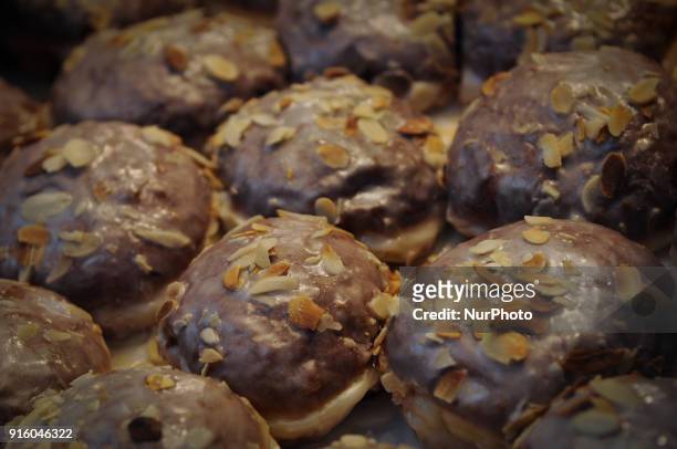 Paczki with almonds or Polish donuts are seen on display at a bakery on Tlusty Czwartek on February 8, 2018. Tlusty Czwartek or Fat Thursday is the...