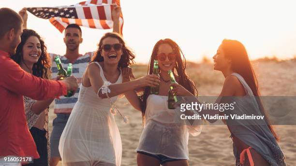hipster  friends at beach on sunset - lens flare young people dancing on beach stock pictures, royalty-free photos & images