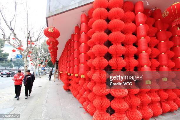 Passengers walk past an intangible cultural heritage museum decorated with red lanterns on February 9, 2018 in Shaoxing, Zhejiang Province of China....
