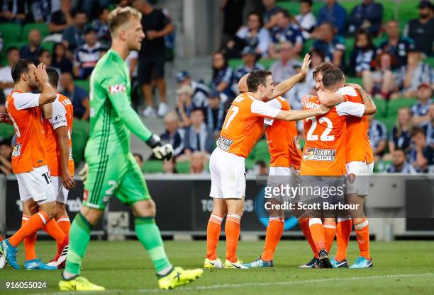 Brett Holman of the Roar is congratulated by his teammates after scoring the Roars second goal as Victory goalkeeper Lawrence Thomas looks on during...