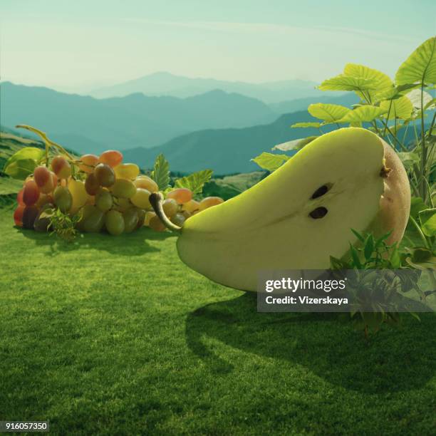 pera gigante surreale e uva in campo di montagna - gigante personaggio fantastico foto e immagini stock