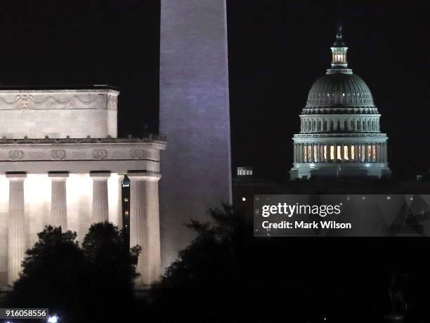 Lights shine at The U.S. Capitol along with the Washington Monument, and Lincoln Memorial in the early hours of Friday morning on February 9, 2018 in...