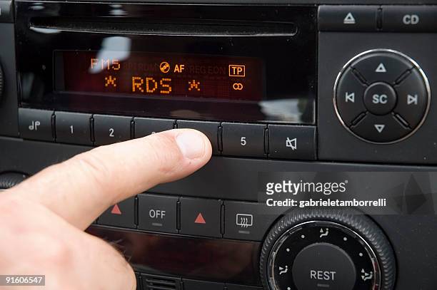 close-up of finger adjusting car radio system - auto radio stockfoto's en -beelden