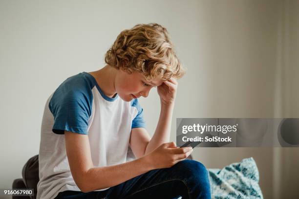 teenage boy uses phone - one teenage boy only stock pictures, royalty-free photos & images