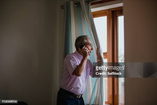 senior homme au téléphone - regarder à la dérobée photos et images de collection