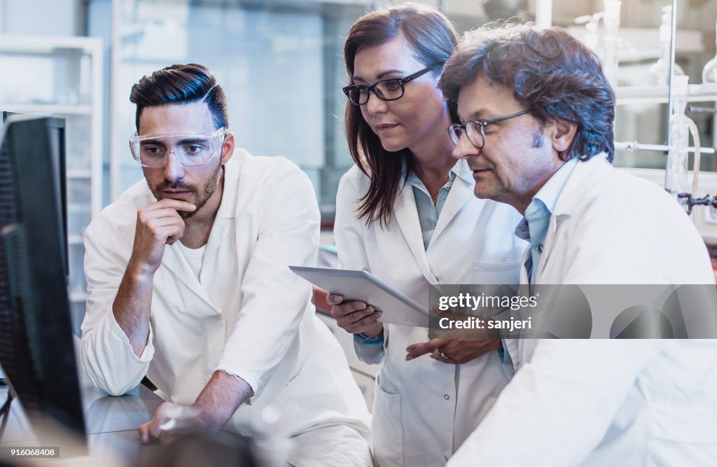 Scientists Discussing In The Laboratory Using Computer High-Res Stock ...