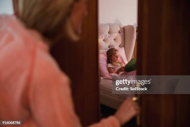 mother checks on daughter - peek stock pictures, royalty-free photos & images