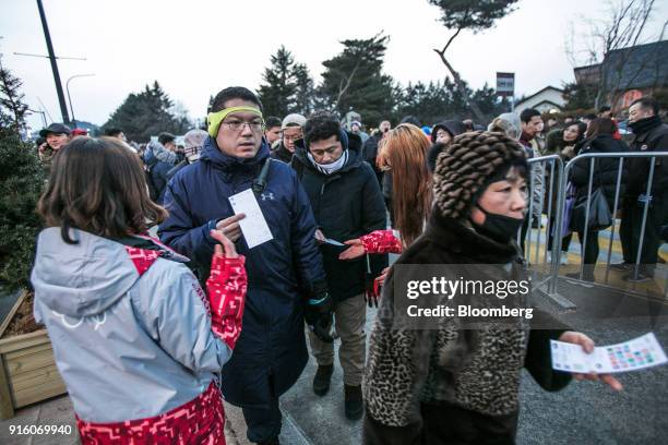 Attendees show their tickets to volunteers as they enter the PyeongChang Olympic Plaza ahead of the opening ceremony of the 2018 PyeongChang Winter...