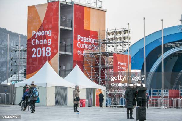 Attendees, right, take a selfie photograph at the PyeongChang Olympic Plaza ahead of the opening ceremony for the 2018 PyeongChang Winter Olympic...