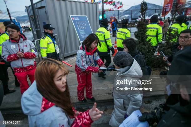 Attendees show their tickets to volunteers as they enter the PyeongChang Olympic Plaza ahead of the opening ceremony of the 2018 PyeongChang Winter...