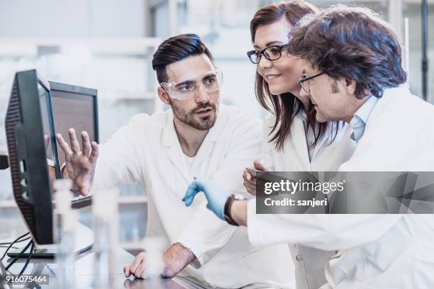 scientists discussing in the laboratory, using computer - pharmacy lab stock pictures, royalty-free photos & images