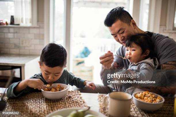 Father and children having breakfast in kitchen