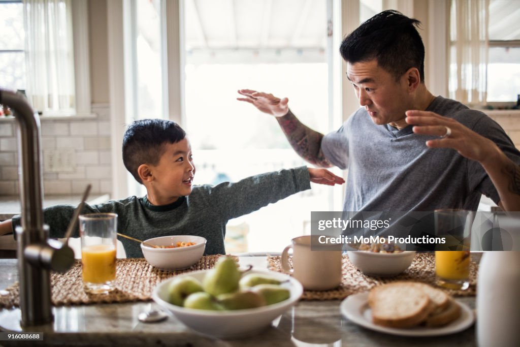 Father and son having breakfast in kitchen