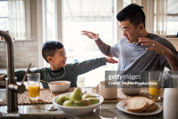 father and son having breakfast in kitchen - breakfast fathers imagens e fotografias de stock