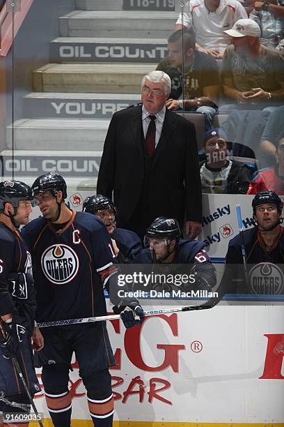 Robyn Regehr of the Calgary Flames checks Ales Hemsky of the Edmonton Oilers into the boards during the game on September 23, 2009 at Rexall Place in...