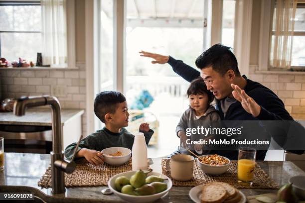 father and children having breakfast in kitchen - alleinerzieher stock-fotos und bilder