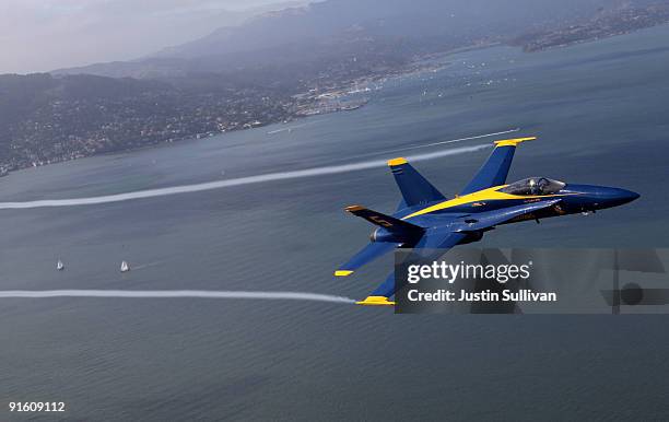 Navy Blue Angels F/A-18 Hornet piloted by U.S. Marine Corps Major Nathan Miller flies over the San Francisco Bay during a practice flight ahead of...