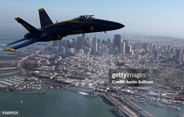 Navy Blue Angels F/A-18 Hornet piloted by U.S. Marine Corps Major Nathan Miller flies past the San Francisco skyline during a practice flight ahead...