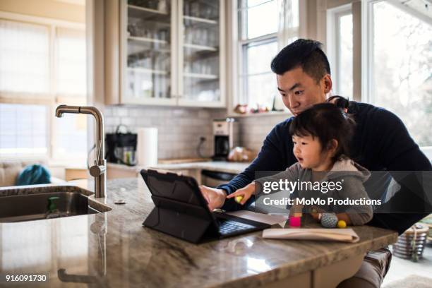 father working in kitchen with daughter - pai dono de casa - fotografias e filmes do acervo