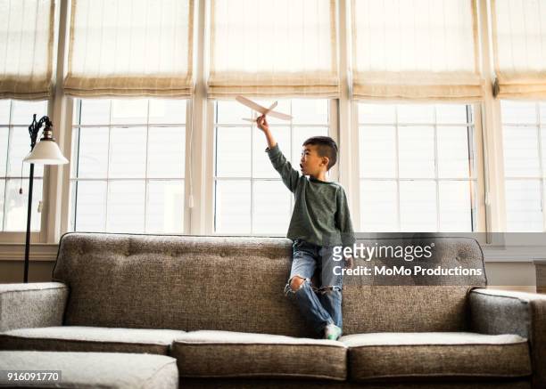 Boy playing with toy glider at home