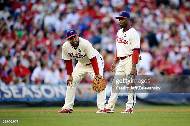 Miguel Cairo and Jimmy Rollins of the Philadelphia Phillies look on during a pitching change against the Colorado Rockies in Game Two of the NLDS...