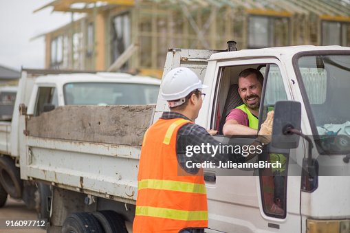 Construction site workers talking before leaving building site Construction site workers talking before leaving building site