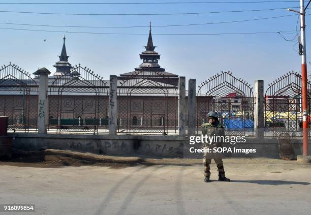 An Indian policeman stands guard outside the historic mosque during curfew in Srinagar. Authorities imposed restrictions in some parts of Srinagar on...
