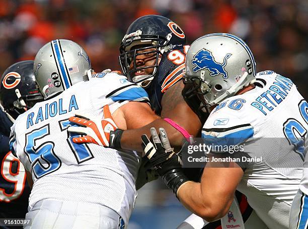 Marcus Harrison of the Chicago Bears is double-teamed while rushing by Dominic Raiola and Stephen Peterman of the Detroit Lions on October 4, 2009 at...