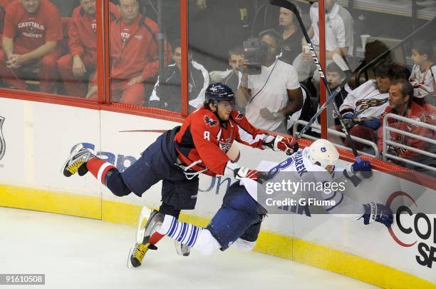 Alex Ovechkin of the Washington Capitals checks Michael Komisarek of the Toronto Maple Leafs at the Verizon Center on October 3, 2009 in Washington,...