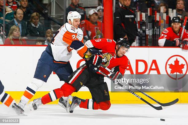 Milan Michalek of the Ottawa Senators is knocked down by Radek Martinek of the New York Islanders during a game at Scotiabank Place on October 8,...