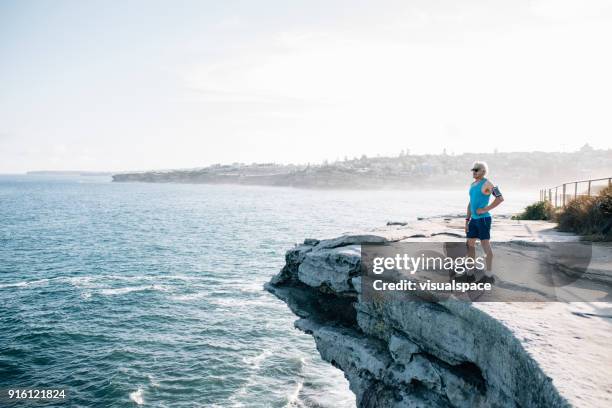 gray hair senior runner with arm band - bondi stock pictures, royalty-free photos & images