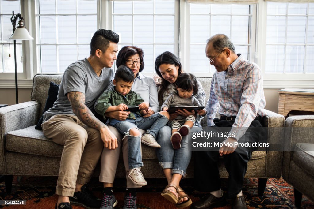 3 generations on couch looking at tablet