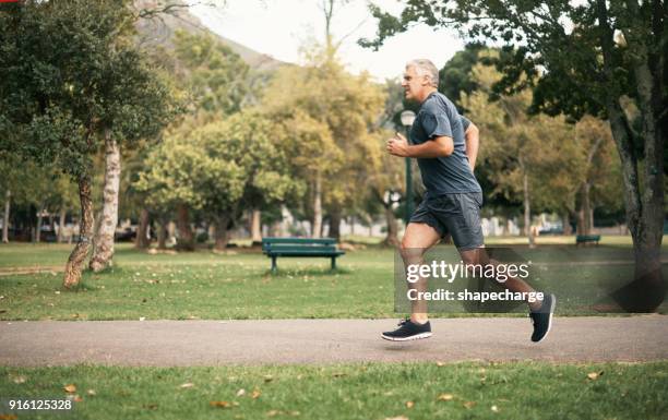 leben auf der gesunden seite des lebens - jogging park stock-fotos und bilder