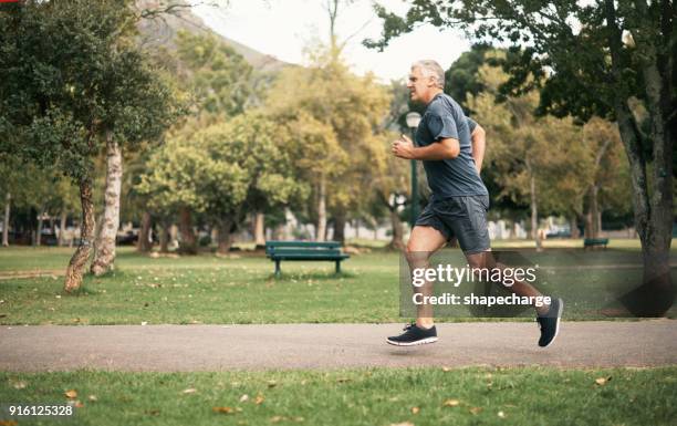 living on the healthy side of life - man jogging stock pictures, royalty-free photos & images