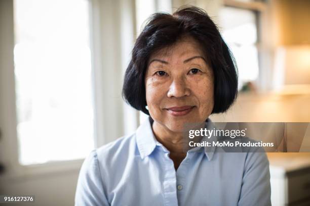 portrait of senior woman at home - chinese people posing for camera stock pictures, royalty-free photos & images