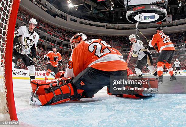 Ryan Parent, Chris Pronger and goaltender Ray Emery of the Philadelphia Flyers watch the puck slide wide of the net as Sidney Crosby and Bill Guerin...