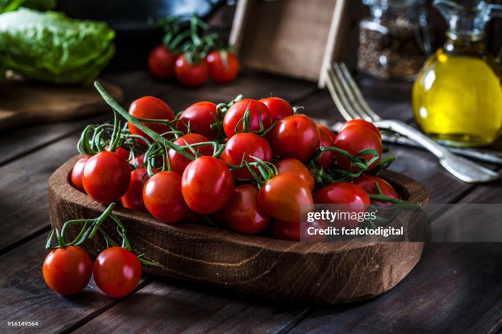 Fresh organic cherry tomatoes shot on rustic wooden table