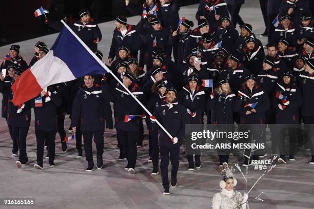 France's flagbearer Martin Fourcade leads his country's delegation during the opening ceremony of the Pyeongchang 2018 Winter Olympic Games at the...