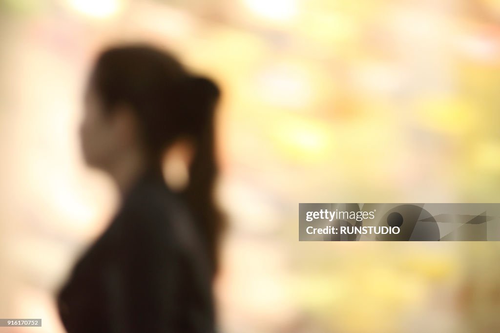 Blurred image of woman walking on street