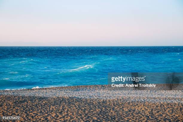 shore of aegean sea, rhodes, greece - stack of sun lounges stock pictures, royalty-free photos & images
