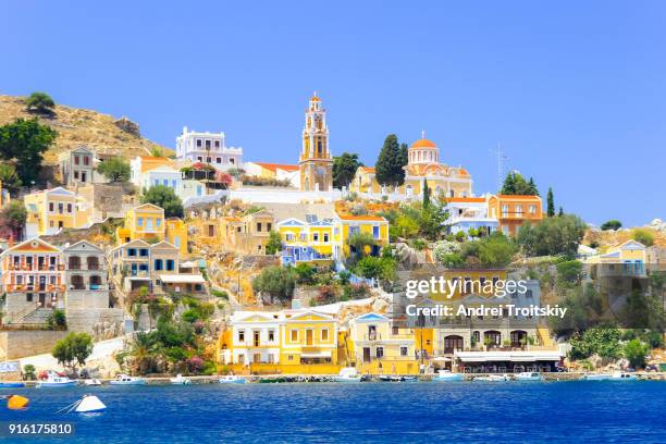 view over harbour to colourful houses and church, symi, dodecanese islands, south aegean, greece - rhodes stockfoto's en -beelden