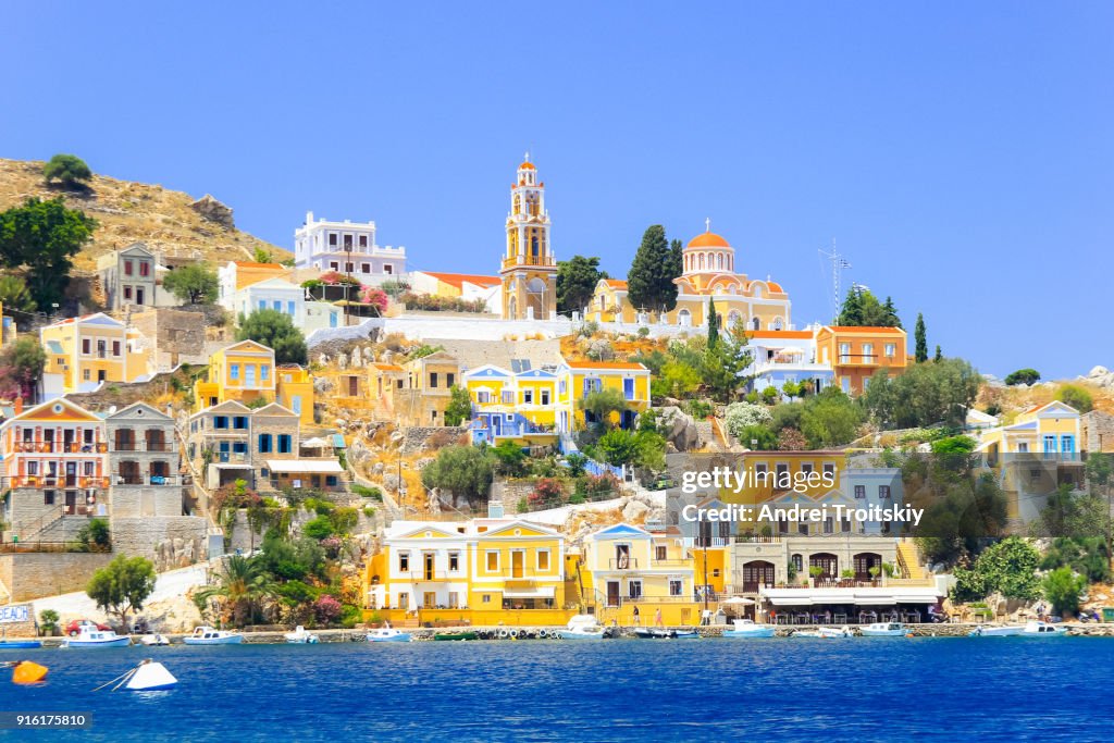 View over harbour to colourful houses and church, Symi, Dodecanese Islands, South Aegean, Greece