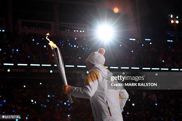 Torchbearer carries the Olympic torch during the opening ceremony of the Pyeongchang 2018 Winter Olympic Games at the Pyeongchang Stadium on February...