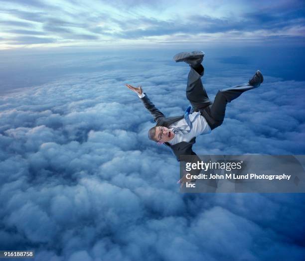 businessman falling in clouds - tomber en chute libre photos et images de collection