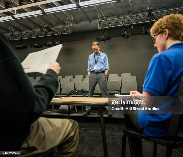 teacher listening to students reading scripts - audition stockfoto's en -beelden