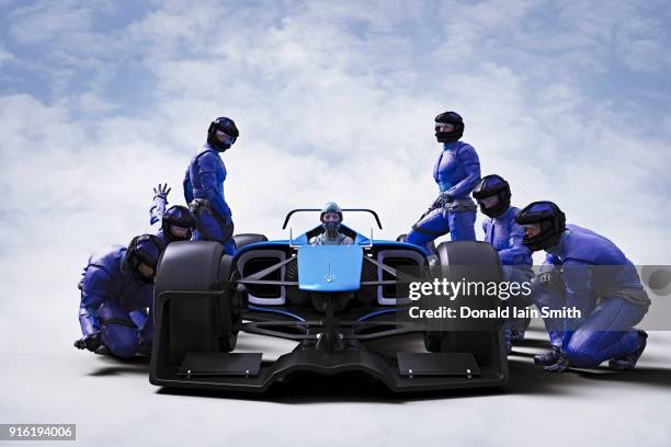 futuristic pit crew servicing race car - arrêt au stand photos et images de collection