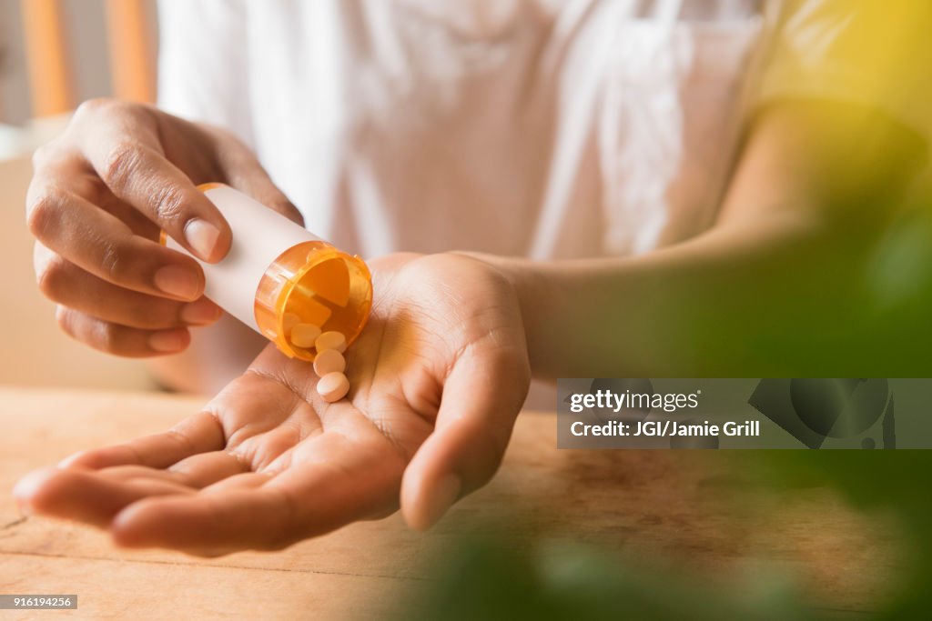 Hands of African American woman holding prescription medicine