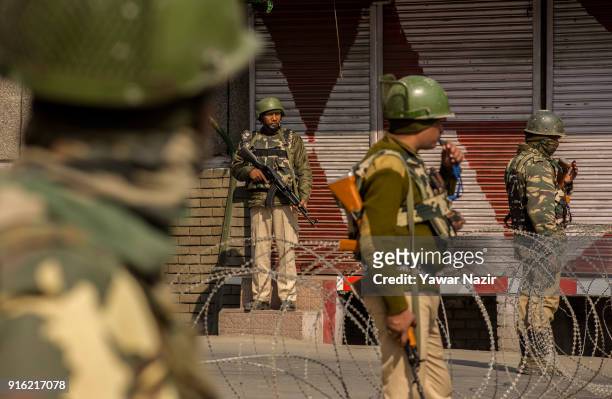 Indian government forces stand guard in front their concertina razor wire, in the Old City during restrictions on the fifth death anniversary of...